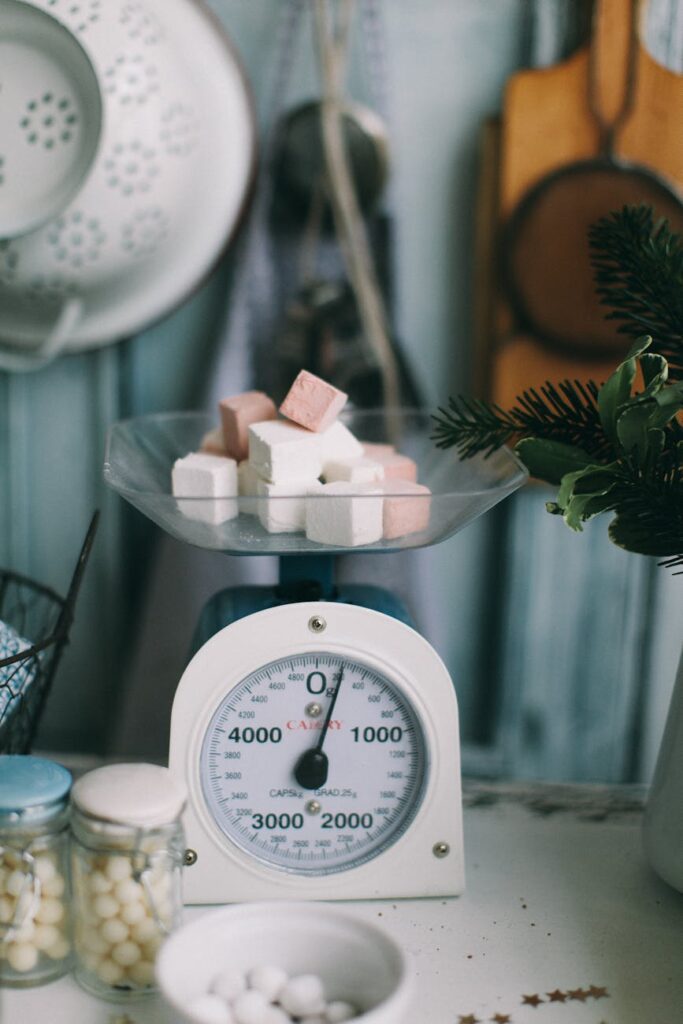 A vintage kitchen scale weighing sugar cubes in a rustic kitchen setting.